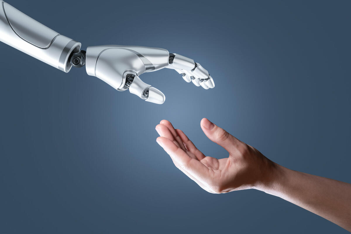Roboterhand mit künstlicher Intelligenz und menschliche Hand © Vithun Khamsong / Getty Images