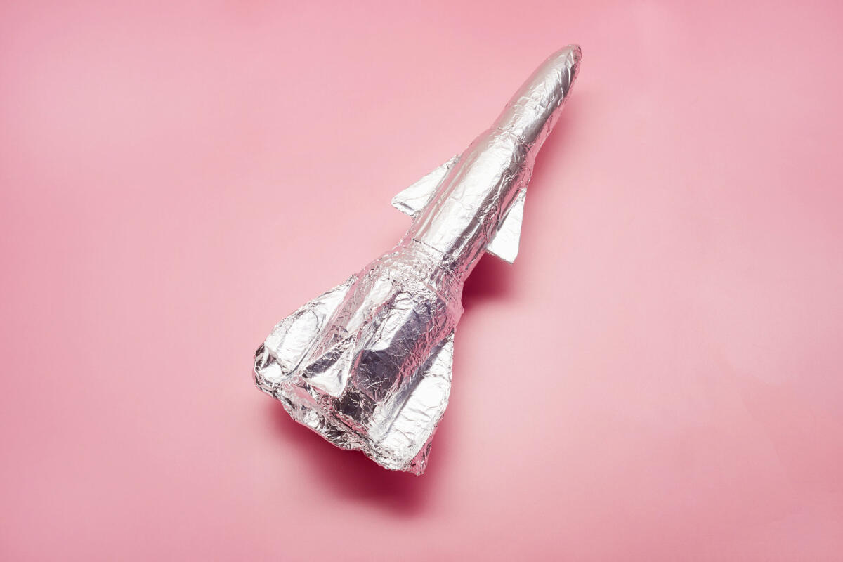 Stilleben einer selbstgebauten Rakete aus Aluminium auf rosa Hintergrund © the_burtons/Getty Images
