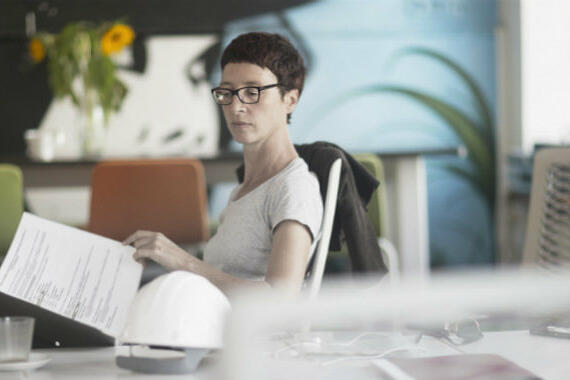Frau sitzt am Schreibtisch und lies Dokumente © Sigrid Gombert / Getty Images
