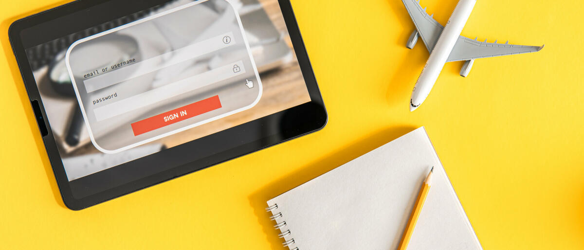 Login-Box, Eingabe von Benutzername und Passwort auf virtueller Digitalanzeige, Notebook und Flugzeug auf gelbem Hintergrund © puhimec / Getty Images