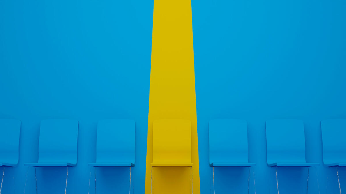 Gelber Stuhl, der sich von der Masse abhebt © marchmeena29 / Getty Images