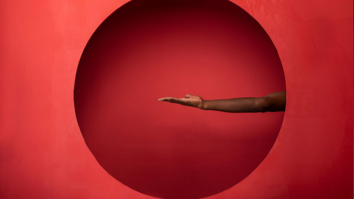 Arm und Hand auf rotem Hintergrund © artur carvalho / Getty Images
