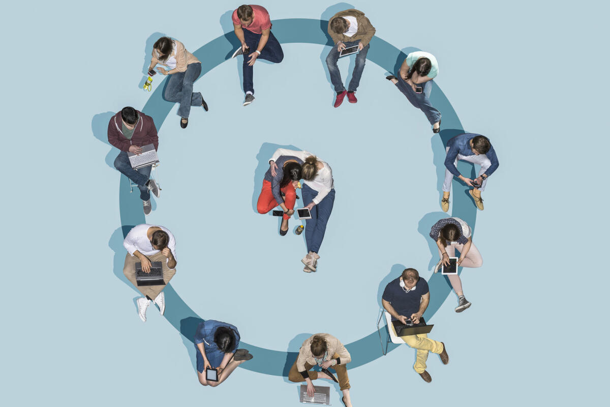 Gruppe junger Menschen, die Technologien nutzen und in einem blauen Kreis sitzen © Bernhard Lang / Getty Images