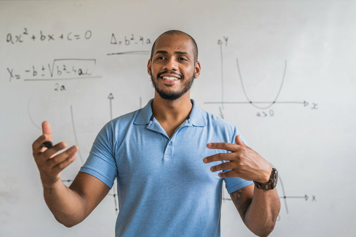 Begeisterter Mathelehrer im Klassenzimmer. © Igor Alecsander/ Getty Images