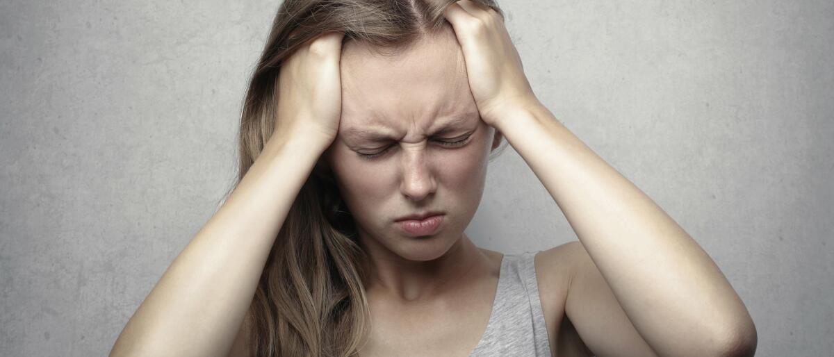 Frau mit Kopfschmerzen fasst sich an den Kopf © Andrea Piacquadio / Pexels