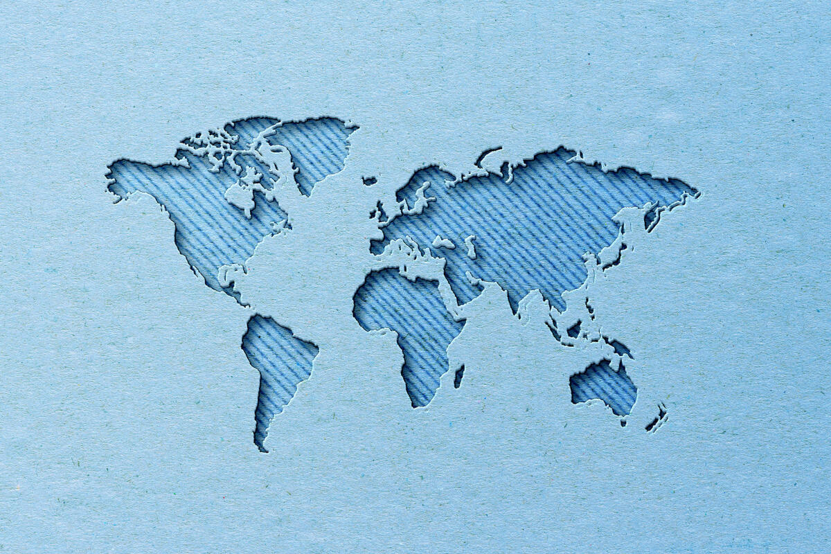 Weltkarte mit Papierschnitt-Effekt auf blauem Hintergrund © Carol Yepes / Getty Images