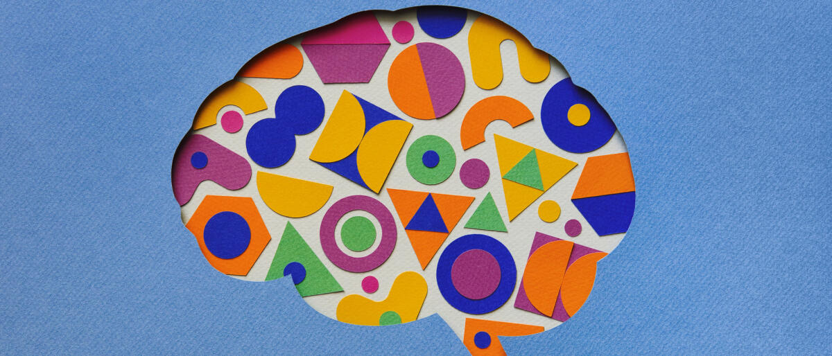 Papierhandwerk Illustration des Gehirns gefüllt mit bunten geometrischen Formen © Eugene Mymrin / Getty Images