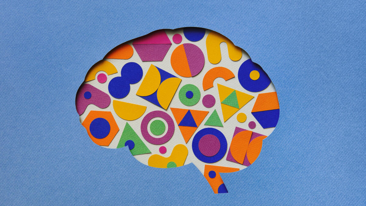 Papierhandwerk Illustration des Gehirns gefüllt mit bunten geometrischen Formen © Eugene Mymrin / Getty Images