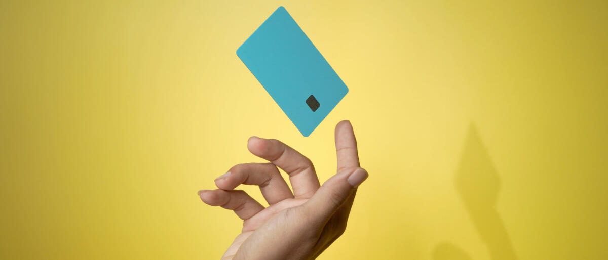 Close up männliche Hand und levitating Vorlage Mockup Bank Kreditkarte mit Online-Service gelben Hintergrund © Wong Yu Liang / Getty Images