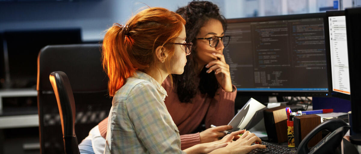 Zwei Programmiererinnen arbeiten an einem neuen Projekt. Sie arbeiten spät in der Nacht im Büro.  © BalanceFormcreative/ Getty Images