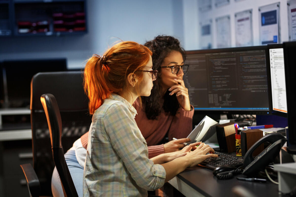 Zwei Programmiererinnen arbeiten an einem neuen Projekt. Sie arbeiten spät in der Nacht im Büro.  © BalanceFormcreative/ Getty Images