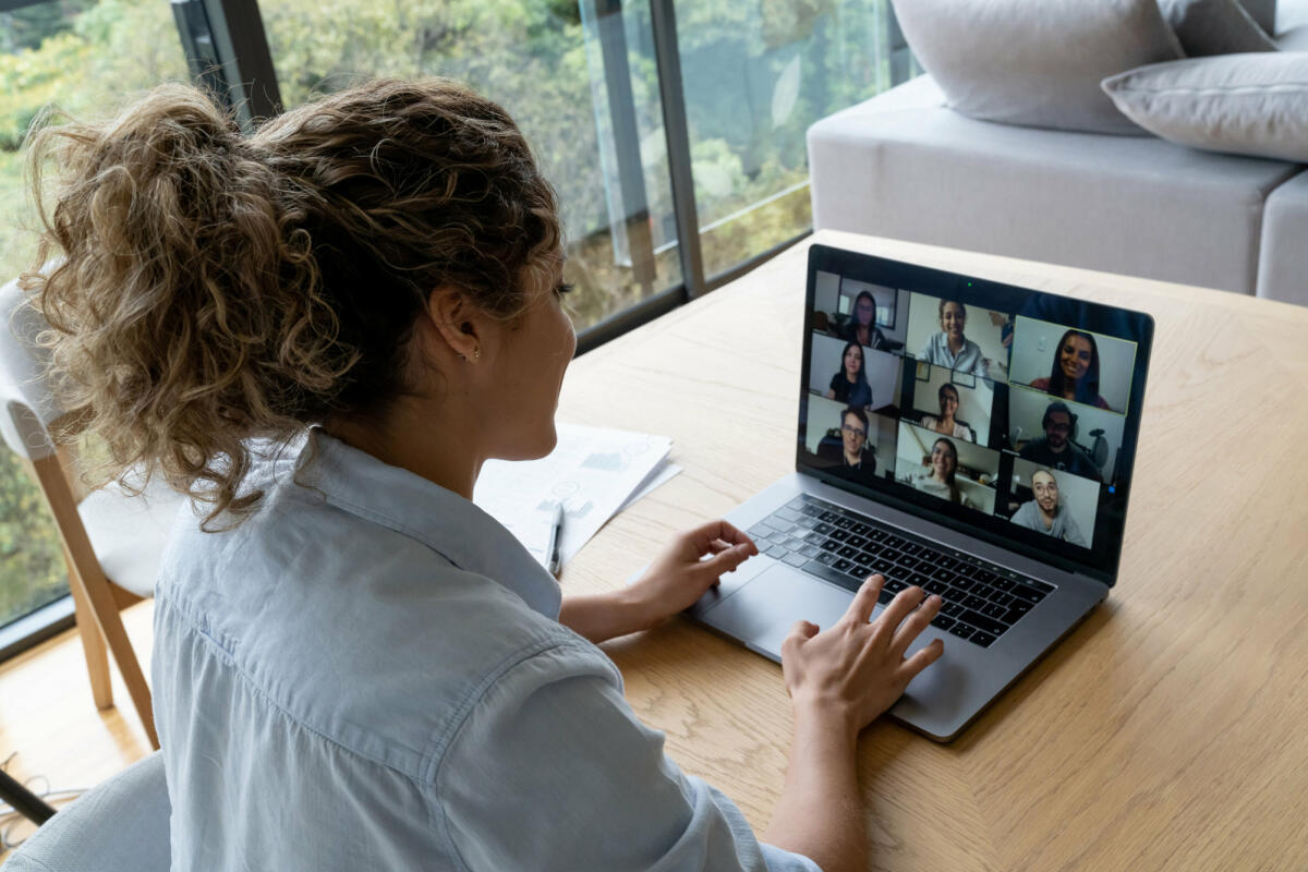 Frau sitzt vor Laptop mit Videokonferenz © andresr / Getty Images