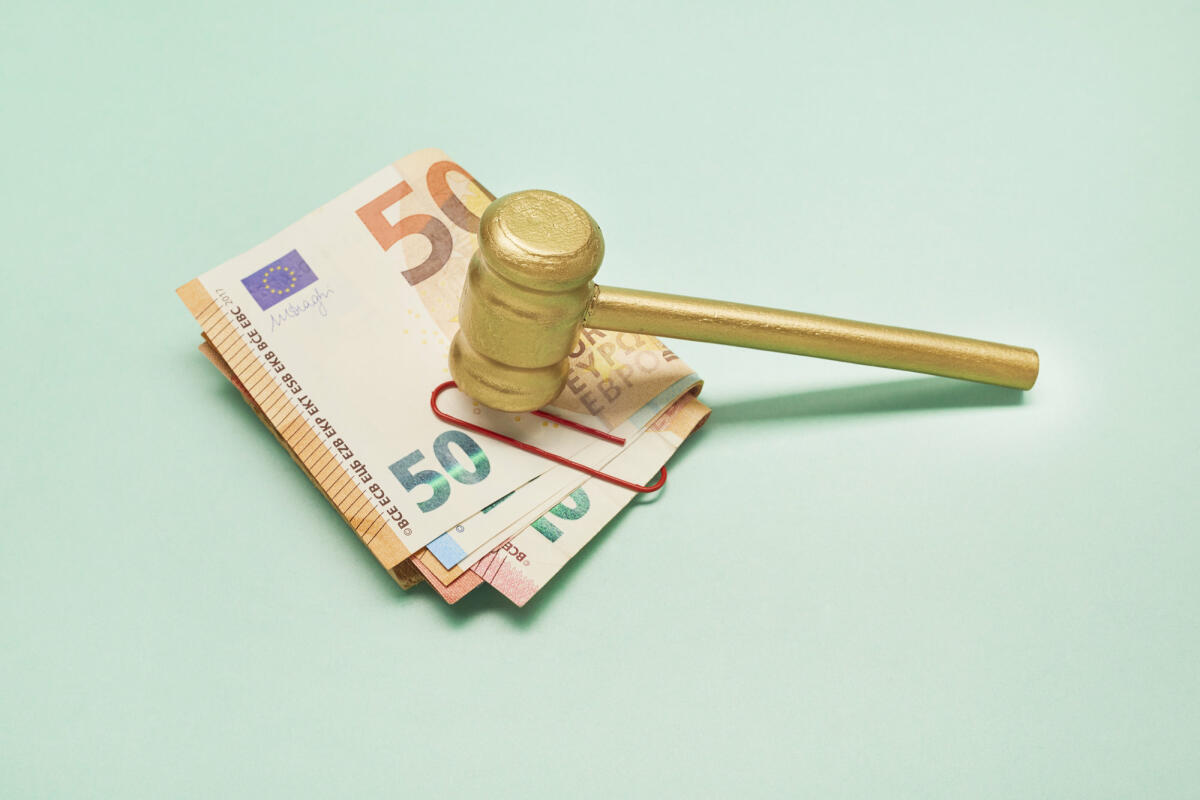 Euro-Banknoten und goldenem Richterhammer (Hammer) auf grünem Hintergrund © the_burtons / Getty Images