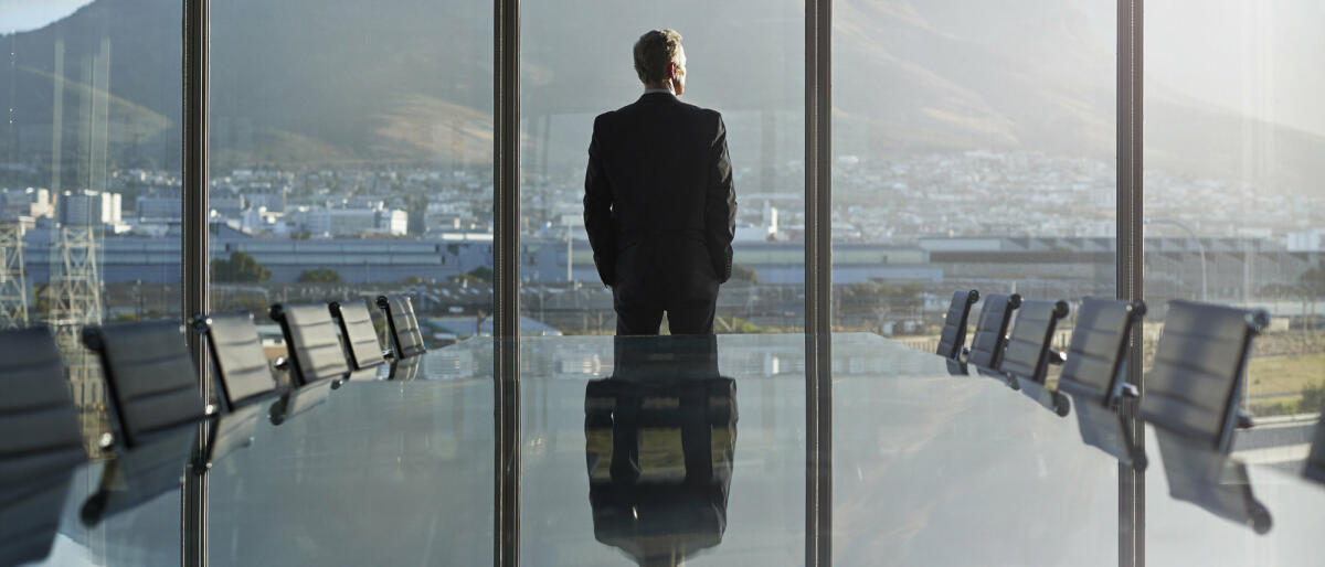 Portraits eines männlichen CEOs, der vor einer großen Glasfront steht und hinausblickt © Klaus Vedfelt / Getty Images