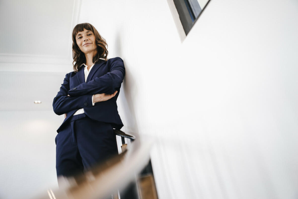 Business-Frau steht auf Stufen © Westend61 / Getty Images