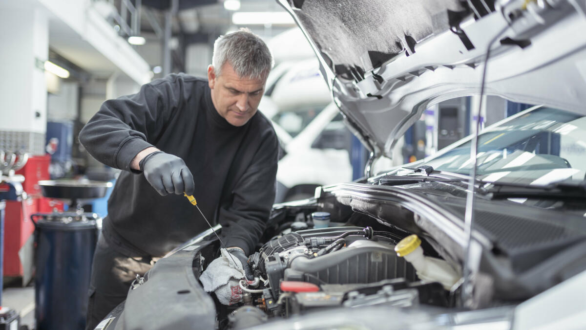Ein erfahrener Automechaniker testet den Ölstand beim Auto.  © Monty Rauken / Getty Images