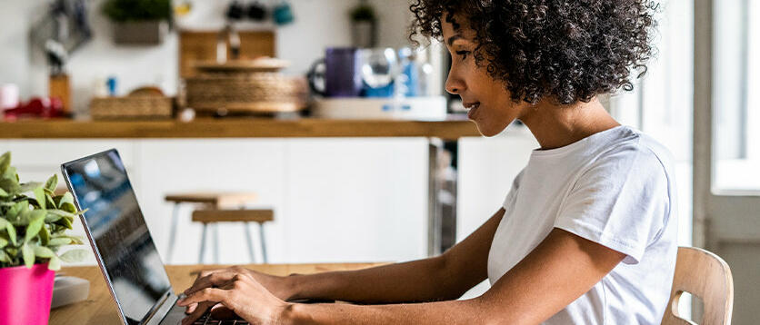 Frau sitzt vor Laptop am Schreibtisch. © Westend61 / Getty Images