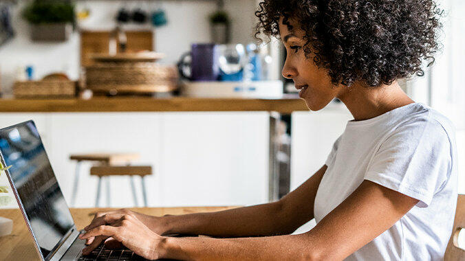 Frau sitzt vor Laptop am Schreibtisch. © Westend61 / Getty Images