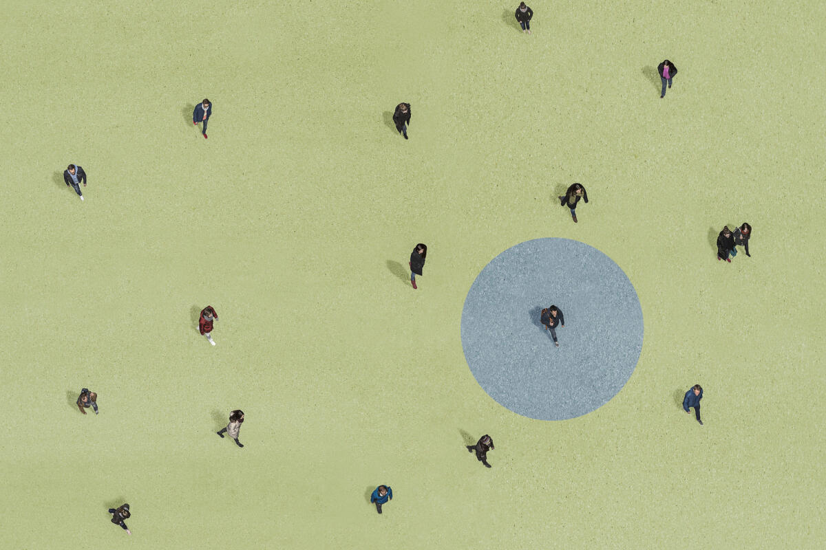Gruppe von Menschen, die auf grünem Grund mit blauem Kreis gehen © Bernhard Lang / Getty Images
