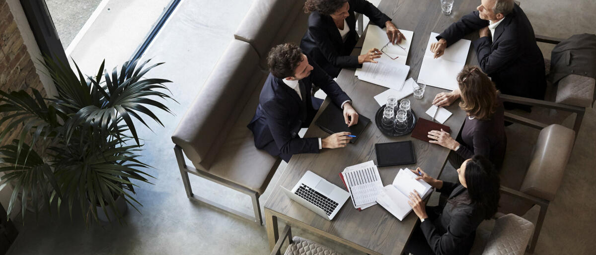 Ein Team von Anwälten plant mit Geschäftskollegen während einer Besprechung in einer Anwaltskanzlei. © Getty Images/ 	Maskot
