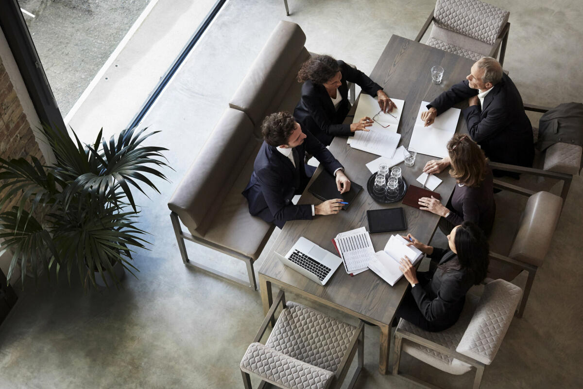 Ein Team von Anwälten plant mit Geschäftskollegen während einer Besprechung in einer Anwaltskanzlei. © Getty Images/ 	Maskot