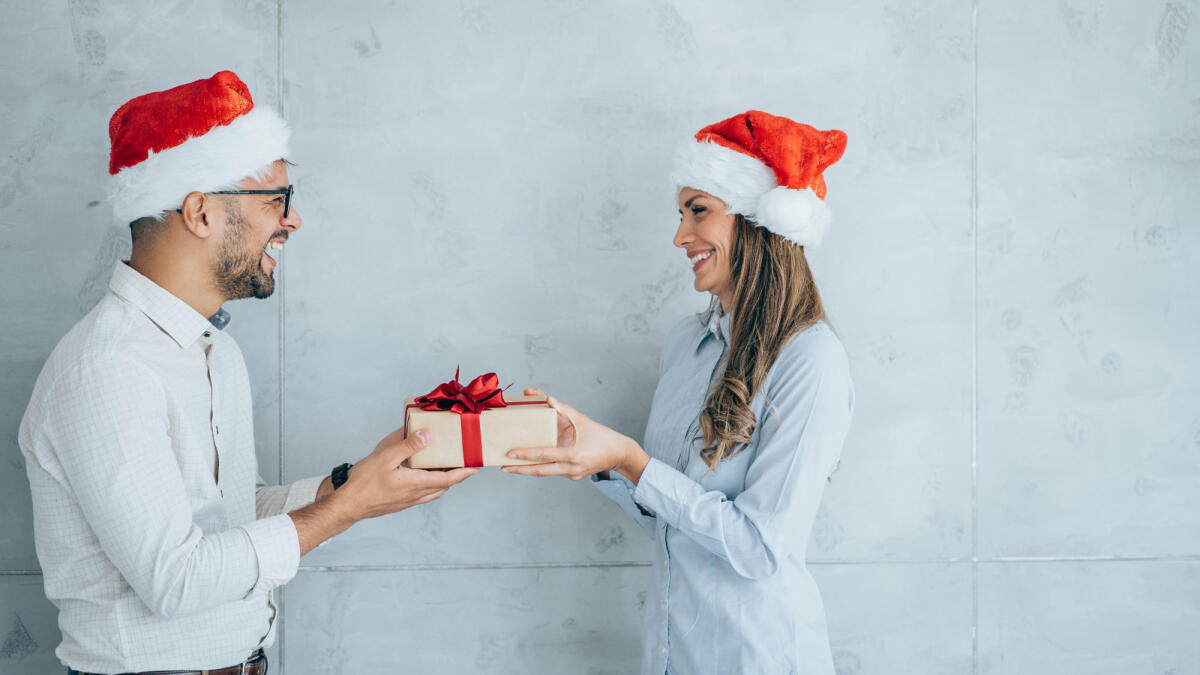 Geschäftsmann schenkt seiner Kollegin ein Geschenk. © VioletaStoimenova / Getty Images
