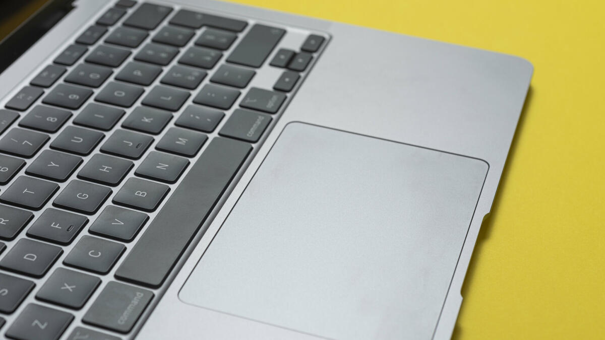 Nahaufnahme einer Laptop-Tastatur auf gelbem Hintergrund. © Francesco Carta fotografo / Getty Images