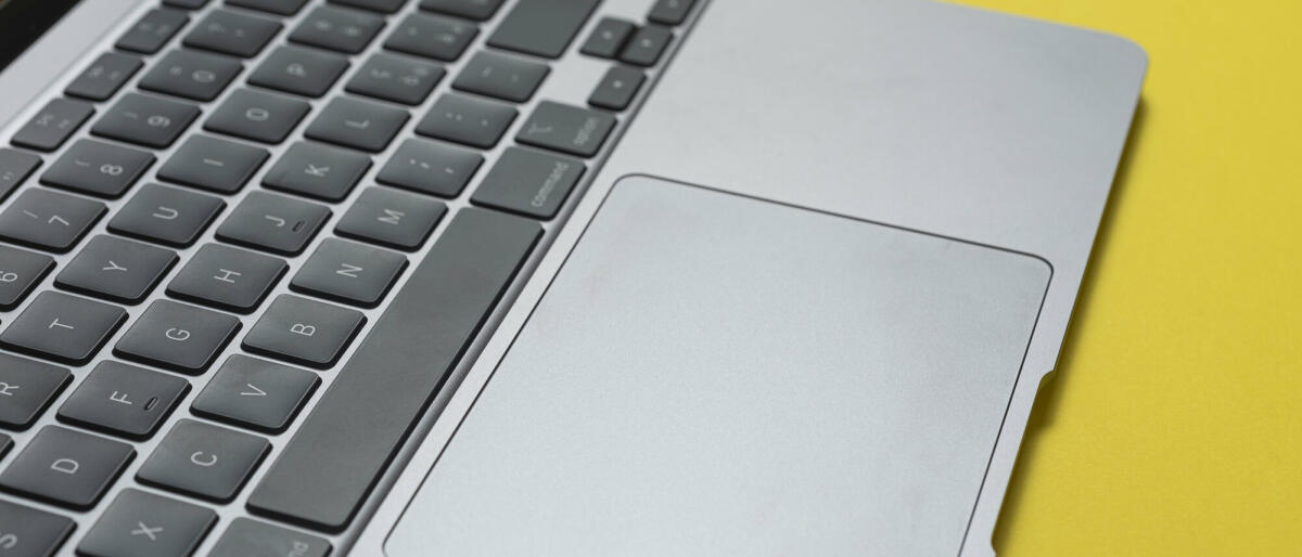 Nahaufnahme einer Laptop-Tastatur auf gelbem Hintergrund. © Francesco Carta fotografo / Getty Images