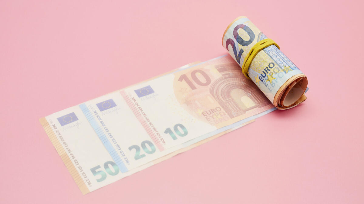 Eine Rolle von Euro Banknoten vor pinkem Hintergrund © the_burtons / Getty Images