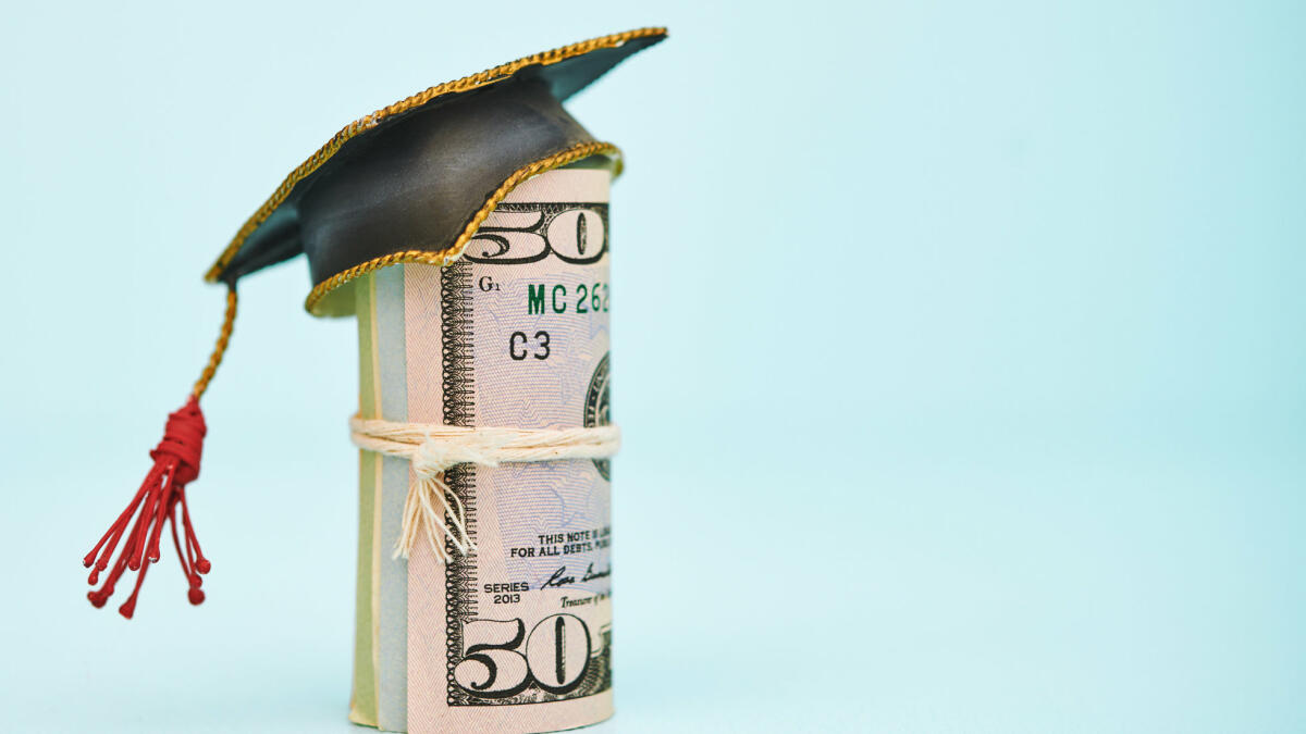 Geldrolle, die eine Kappe zum College-Abschluss trägt © Catherine Lane / Getty Images