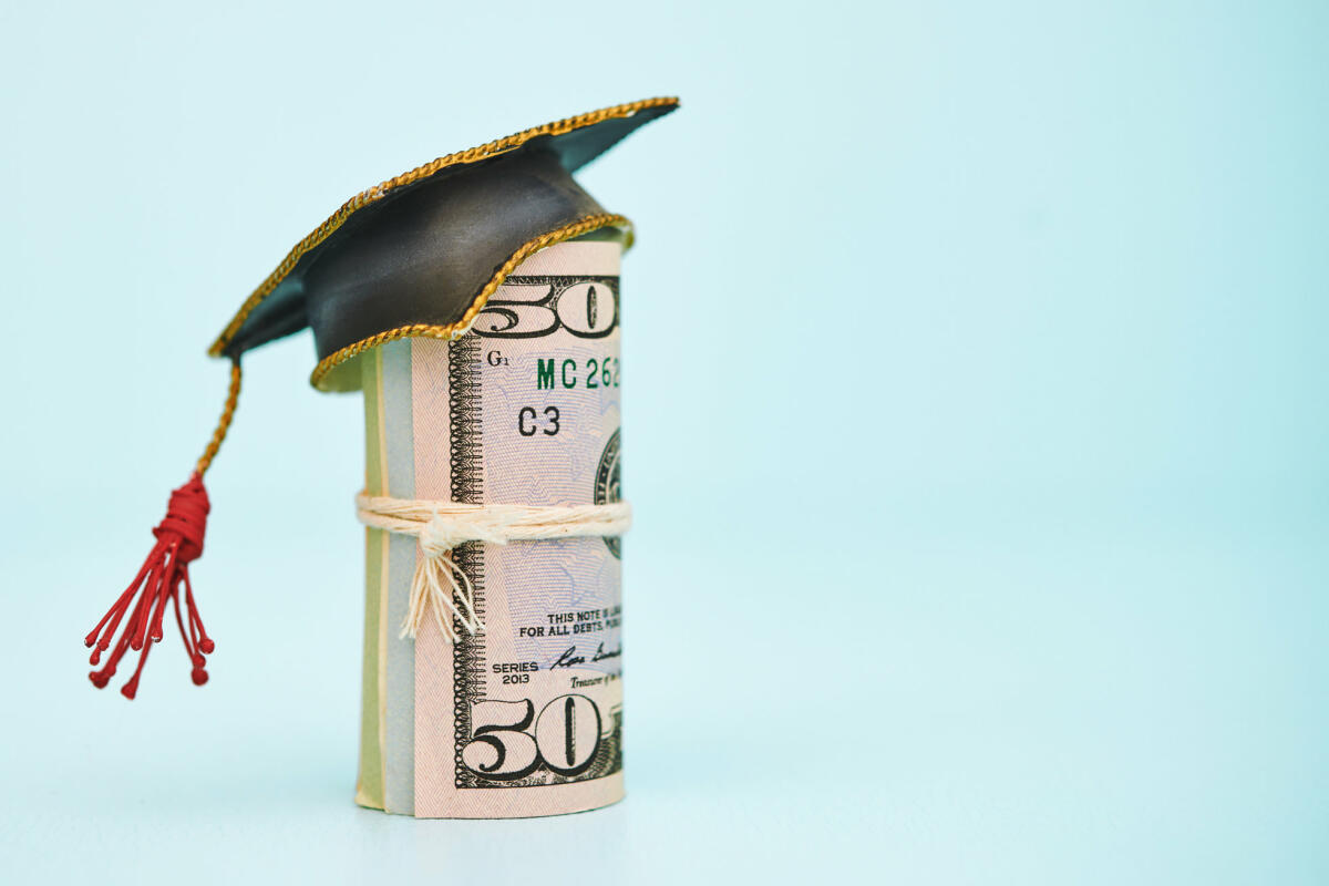 Geldrolle, die eine Kappe zum College-Abschluss trägt © Catherine Lane / Getty Images