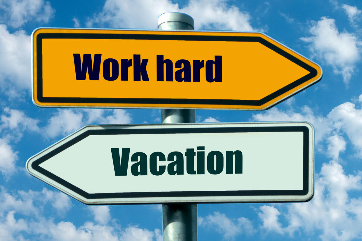 Zwei beschriftete Richtungspfeile zeigen in entgegengesetzte Richtungen: nach rechts: hart arbeiten, nach links: Urlaub © deepblue4you / Getty Images
