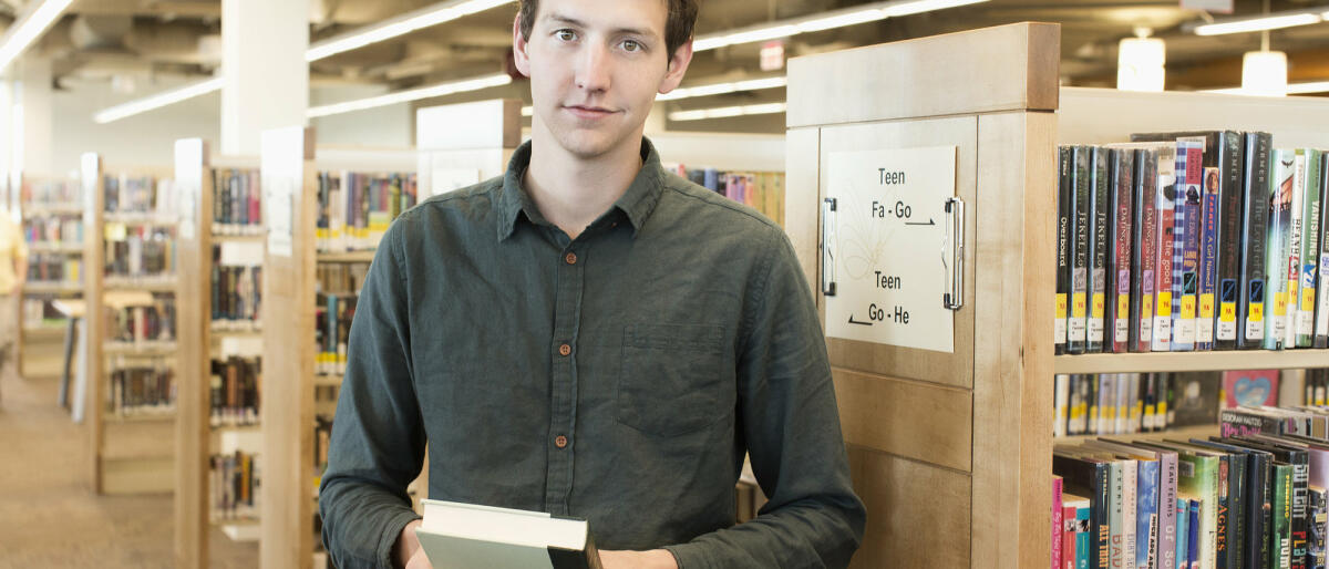 Bibliothekar, der ein Buch hält © Hill Street Studios / Getty Images