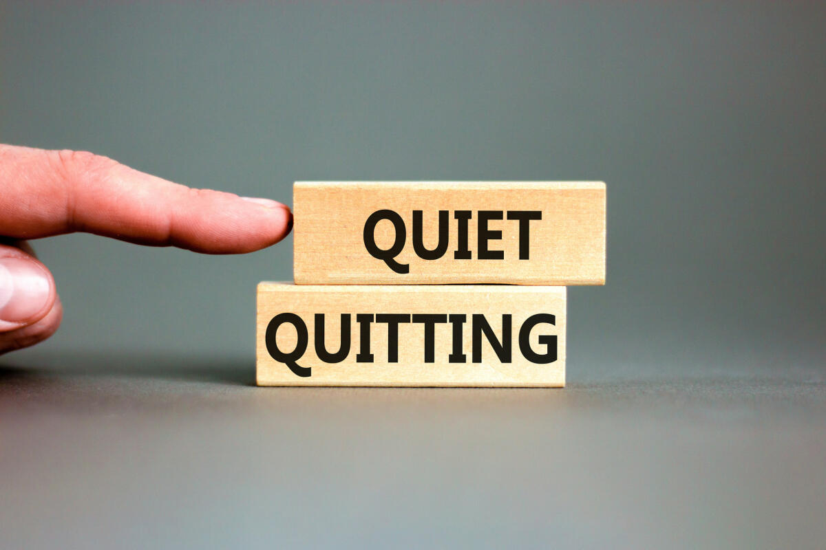 Quiet Quitting geschrieben auf zwei Holzblöcken auf einem grauen Schreibtisch vor grauem Hintergrund © Dzmitry Dzemidovich / Getty Images